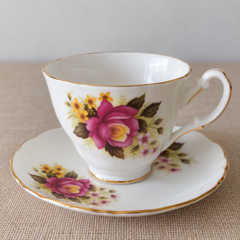 Dúo de té vintage Royal Ascot Fine Bone China inglesa con rosa burdeos, flores amarillas y detalles dorados.