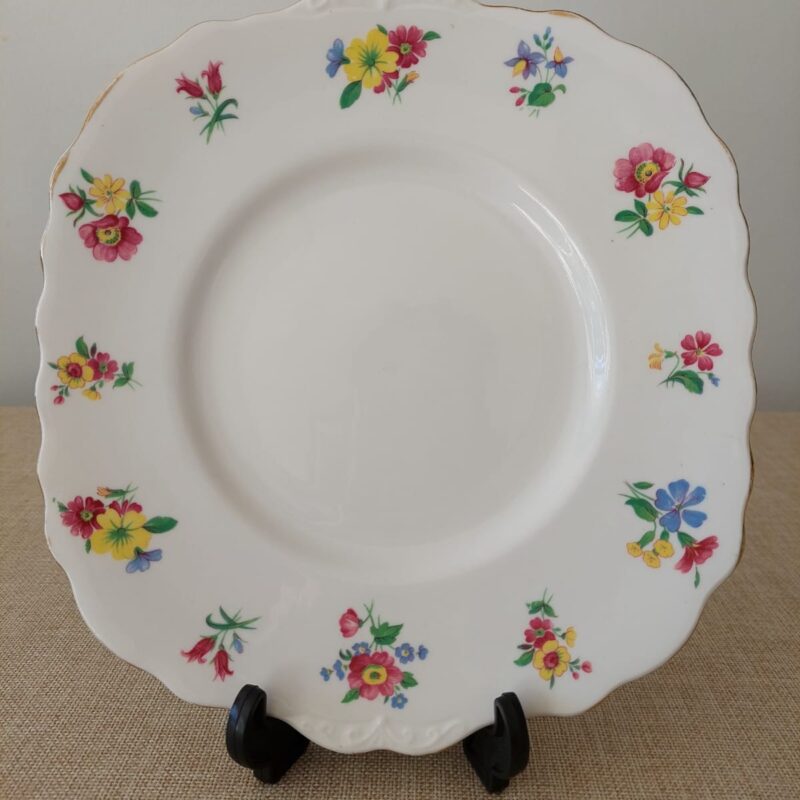 "Plato vintage de porcelana Royal Vale con flores de colores y borde de oro."