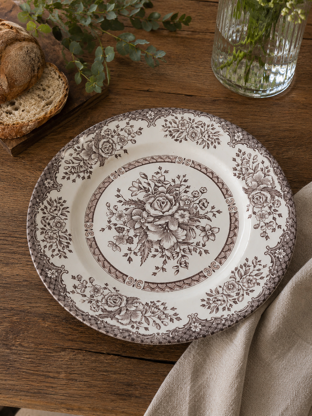 Vista frontal de un plato principal de loza crema inglesa Staffordshire Tableware con un intrincado diseño transferware marrón de rosas y ramos de flores.