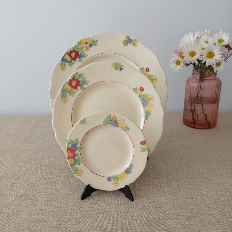 Trío escalonado de platos vintage de loza Royal Doulton Minden con bordes festoneados y ramos florales de colores.