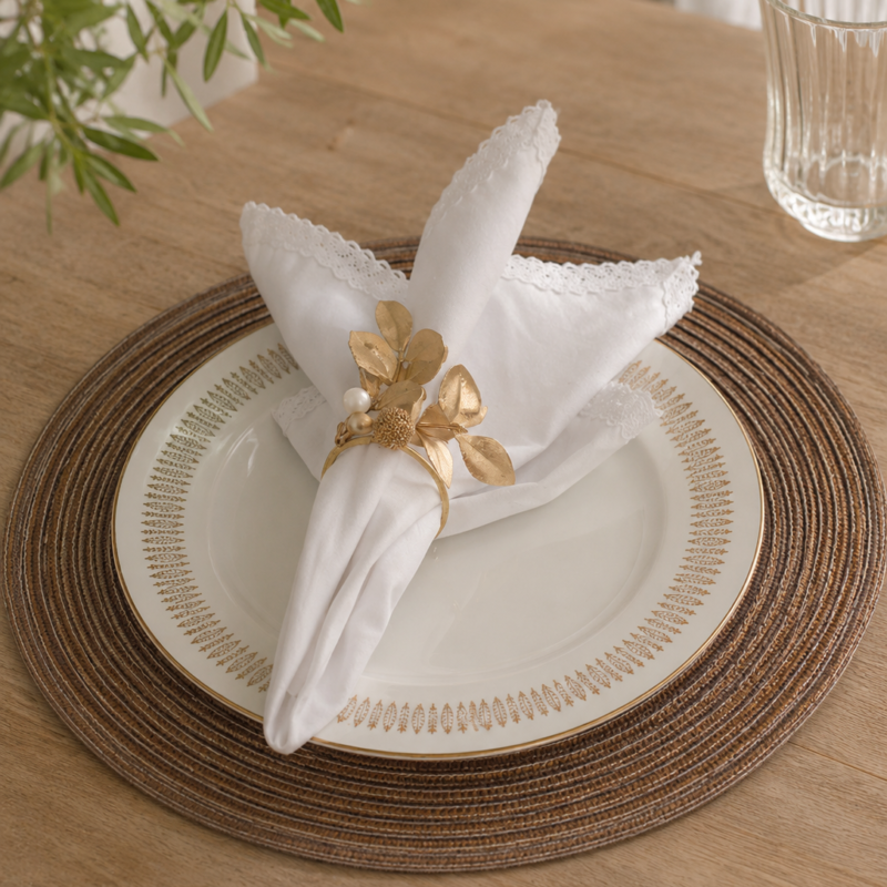 Set de seis aros para servilleta dorados con hojas y detalles botánicos decorativos en tonos champagne y blanco, ideales para mesas elegantes y celebraciones especiales.