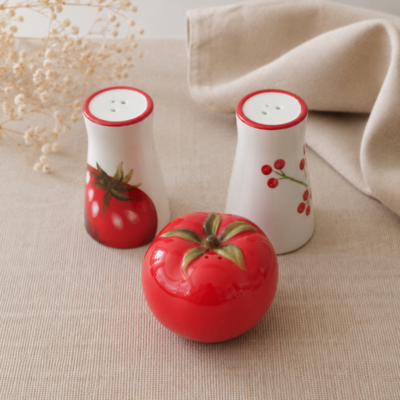 Set de especieros de cerámica esmaltada decorados con motivos de tomate en tonos rojo, verde y blanco, ideal para cocinas de estilo campestre y decoración acogedora.
