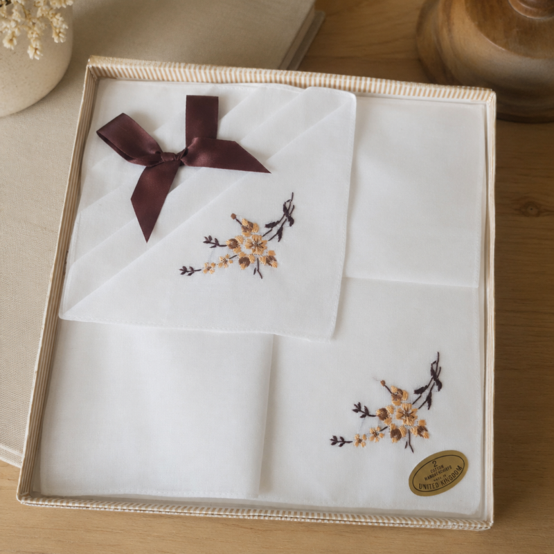 Caja original con dos pañuelos vintage blancos de algodón 100%, bordados a mano, fabricación inglesa circa 1970–1980, nuevos, con bordado floral y presentación original.