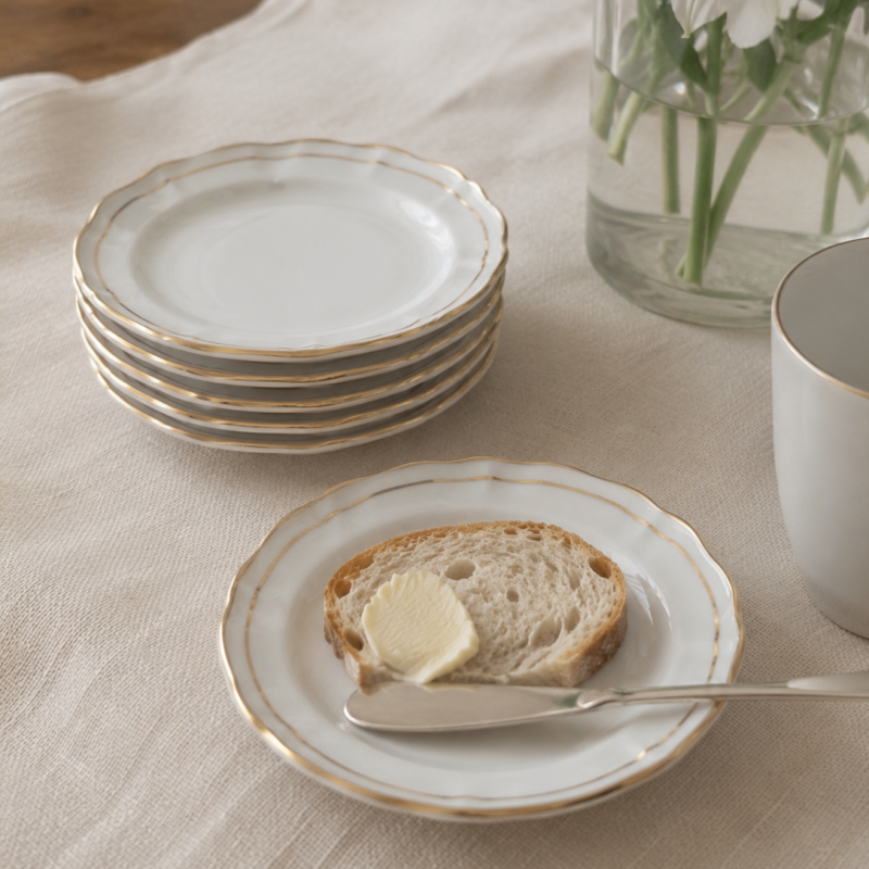 Set de seis platos de pan vintage Duchess Bone China modelo Ascot, porcelana inglesa blanca con delicados bordes ondulados y finos detalles dorados, en excelente estado.