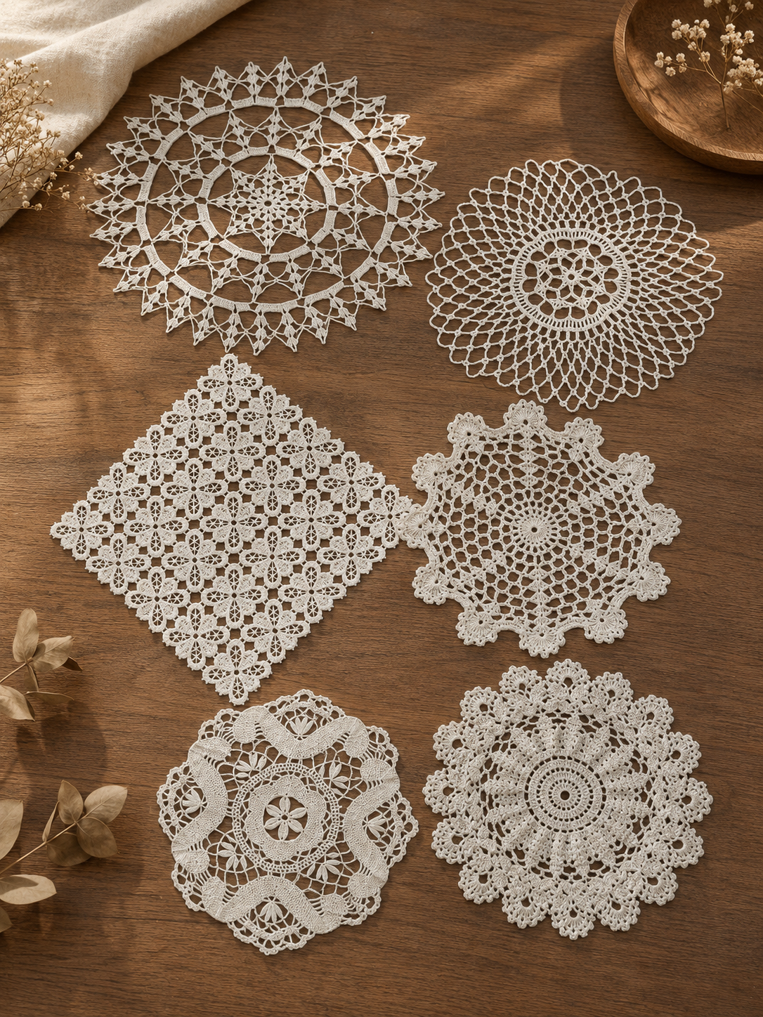 Set de seis tapetes decorativos tejidos a crochet artesanal en color blanco, con diseños circulares calados y diferentes tamaños, ideales para decorar mesas y muebles del hogar.