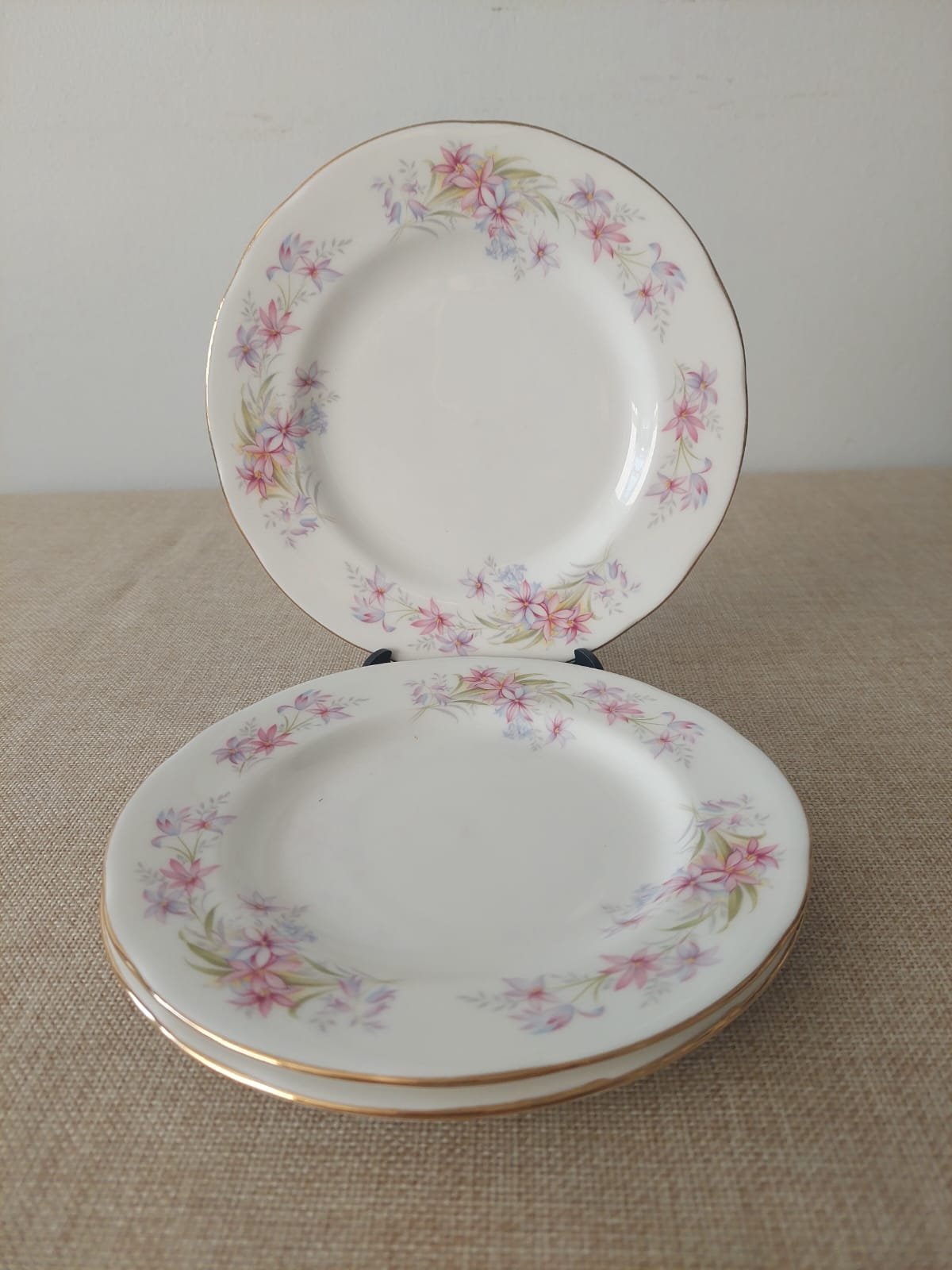 Platos de pan Duchess Bone China Riversong en una mesa de desayuno elegante, acompañados de un croissant, mermelada, té y flores blancas, con luz natural y ambiente acogedor.