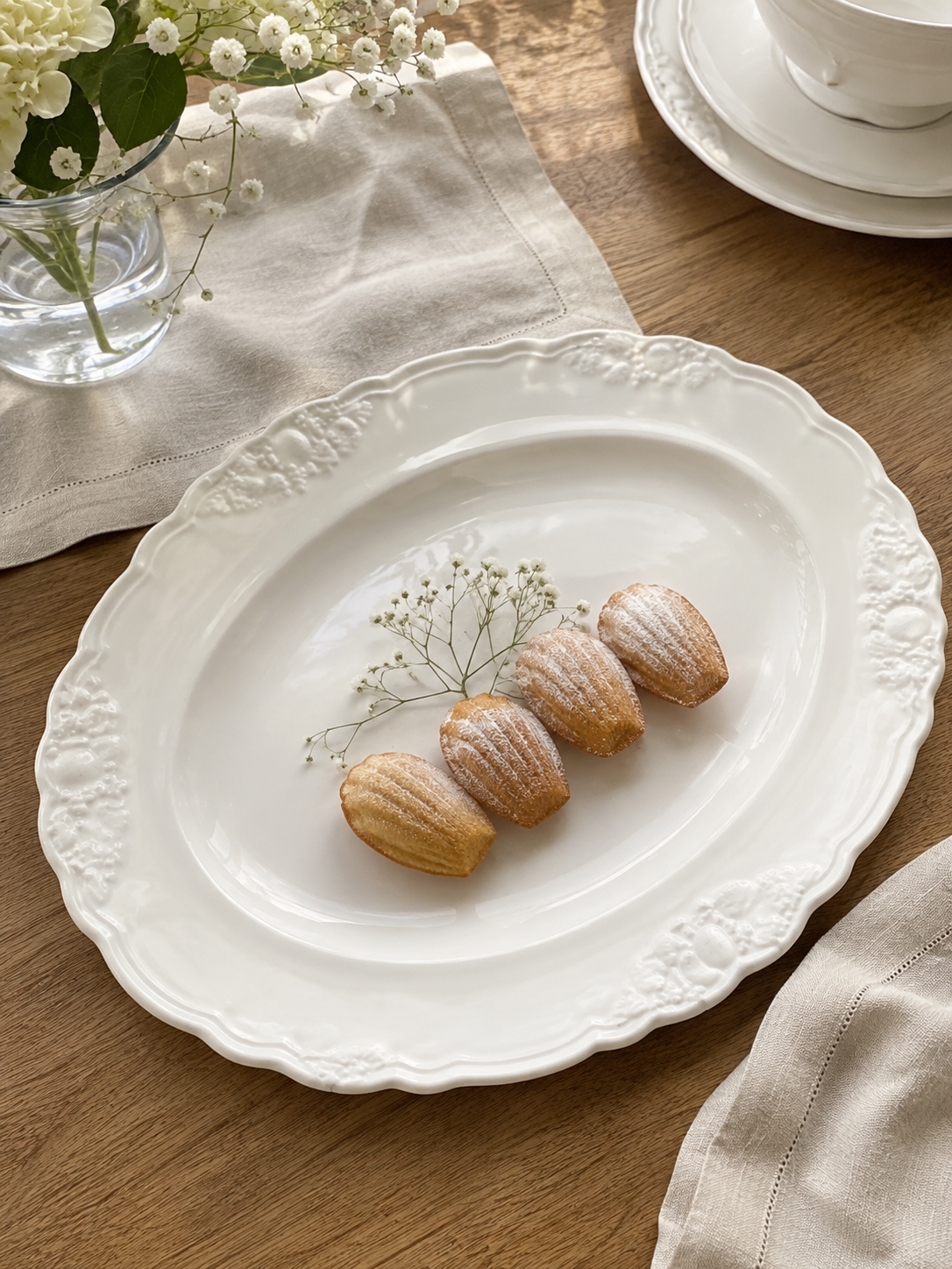 Bandeja ovalada vintage blanca de 26 × 20 cm con borde ondulado y delicados motivos florales en relieve.