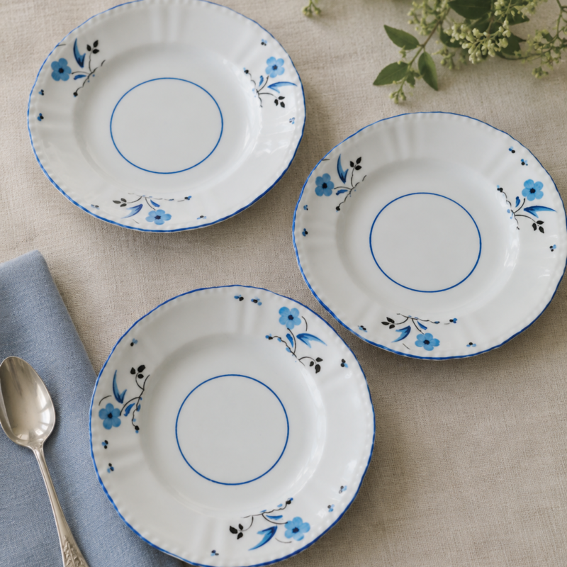Set de 3 platos de té vintage Victoria C&E Bone China England de 15 cm, decorados con pequeñas flores azules y borde ondulado azul.