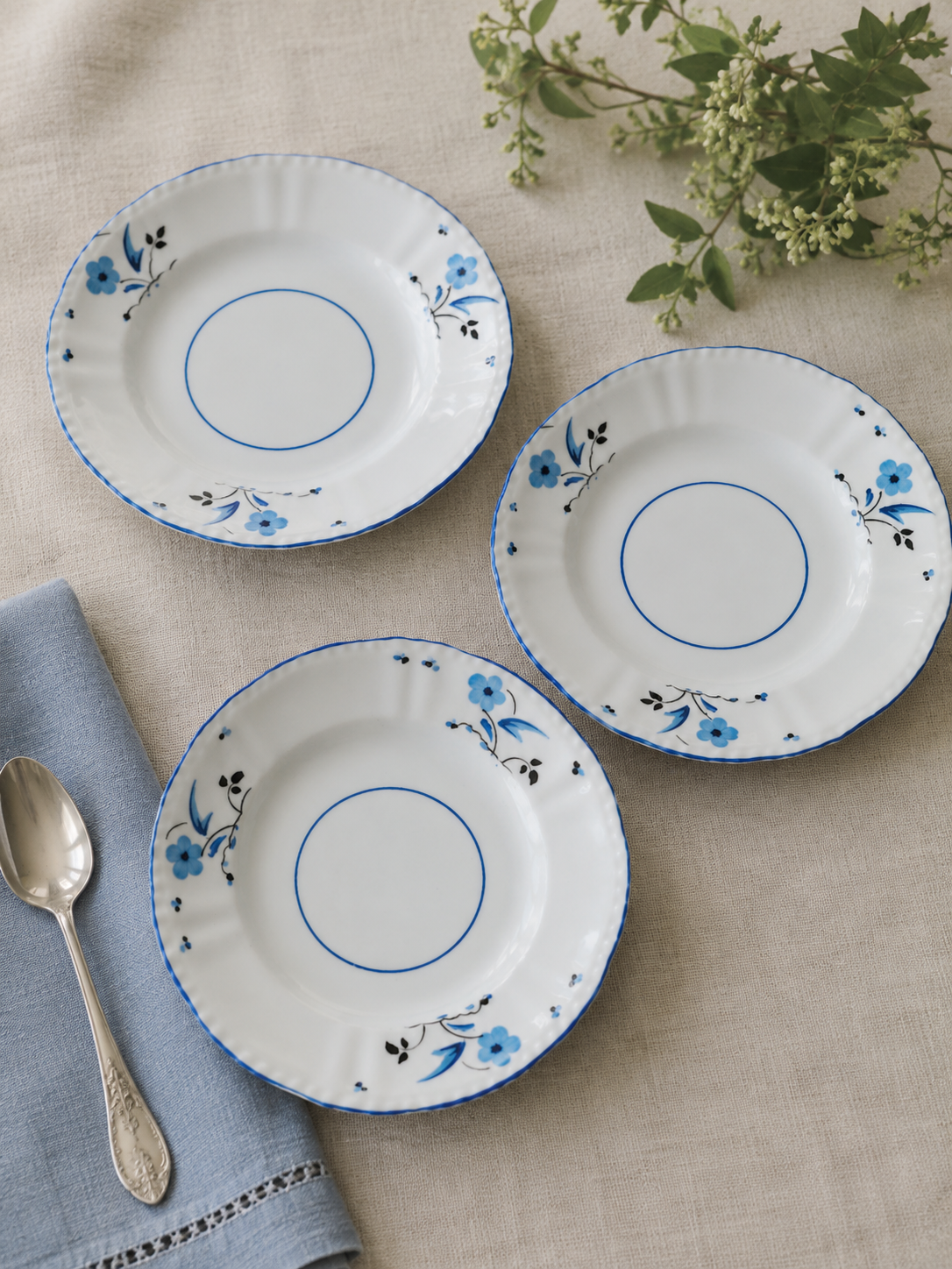 Set de 3 platos de té vintage Victoria C&E Bone China England de 15 cm, decorados con pequeñas flores azules y borde ondulado azul.