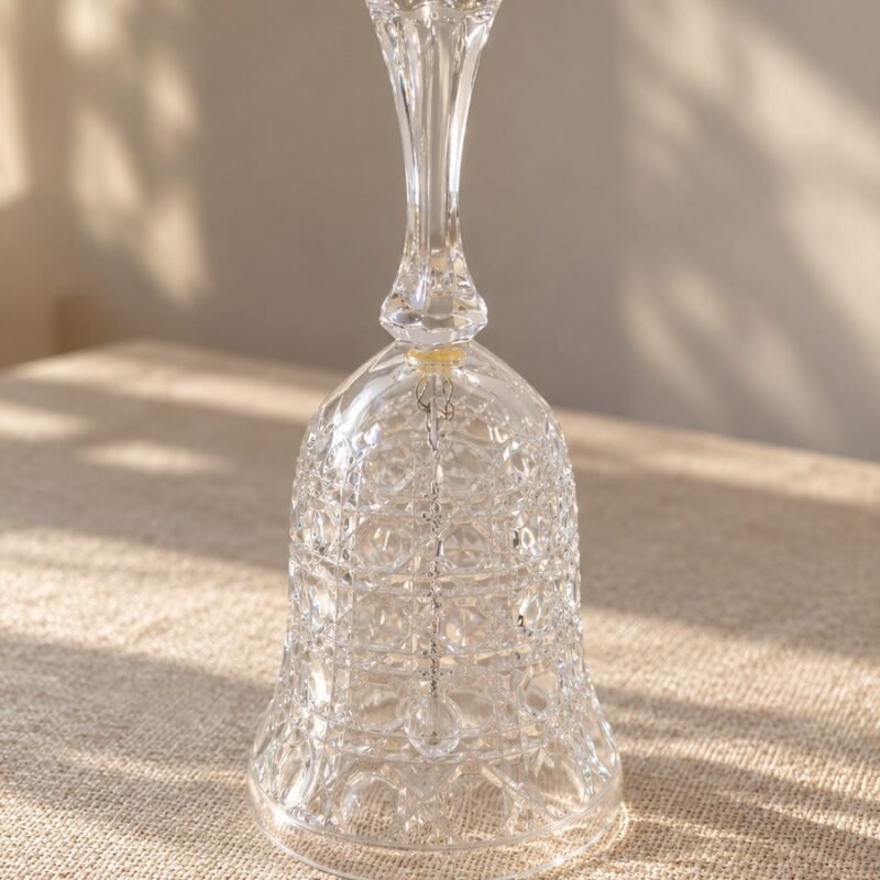 Campana decorativa de cristal transparente tallado de 17 cm con mango facetado y badajo interior.