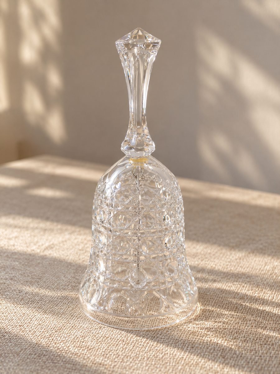 Campana decorativa de cristal transparente tallado de 17 cm con mango facetado y badajo interior.