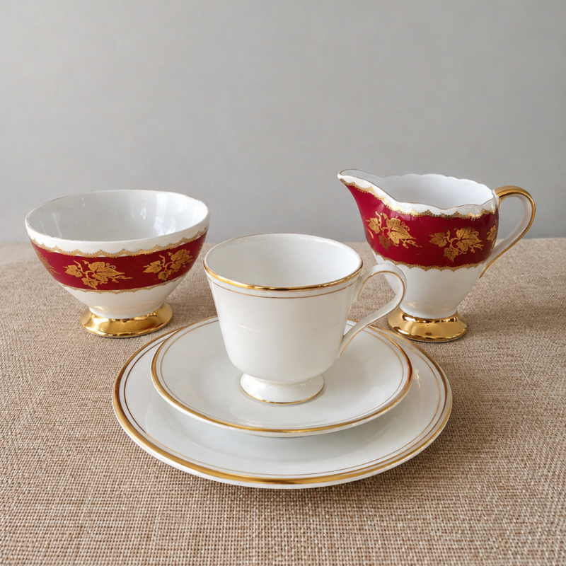 Set de té vintage inglés de 5 piezas Royal Doulton y Gladstone, compuesto por trío blanco con bordes dorados, terronero y cremero burdeos con decoración dorada.
